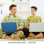 stock-photo-happy-couple-working-on-laptop-computer-at-home-smiling-19167181